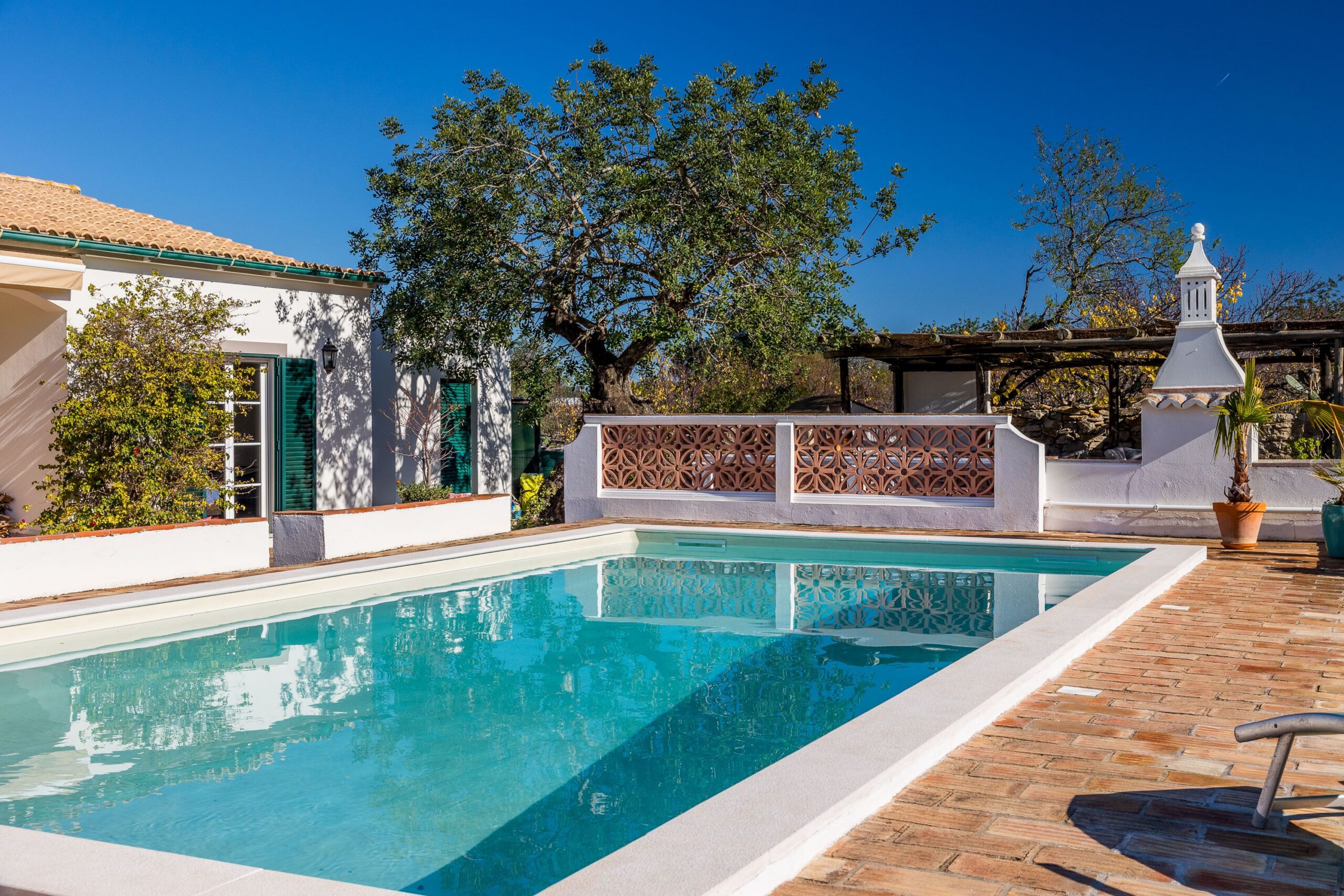 Modern residential building facade with clear blue sky and green landscaping